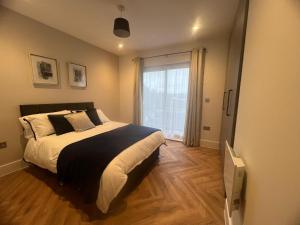 sypialnia z dużym łóżkiem i oknem w obiekcie New 2 Bedroom Apartment Rickmansworth Town Centre w mieście Rickmansworth