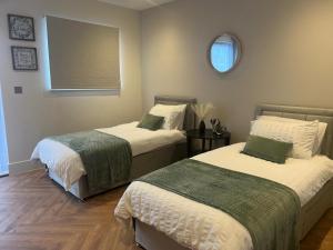 een slaapkamer met 2 bedden en een spiegel bij New 2 Bedroom Apartment Rickmansworth Town Centre in Rickmansworth