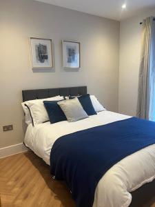 a bedroom with a large bed with blue and white pillows at New 2 Bedroom Apartment Rickmansworth Town Centre in Rickmansworth