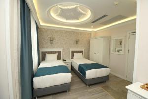 a bedroom with two beds and a ceiling at Novus Hotel İstanbul in Istanbul