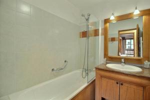 a bathroom with a tub and a sink and a mirror at ARC 1950 - APPARTEMENT MODERNE - SAUNA HAMMAM JACUZZI - 4 Personnes in Arc 1950 +18 photos