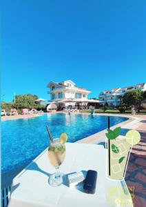 a table with a drink next to a swimming pool at Hotel Comfort & Villas in Donji Štoj