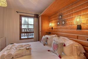 アーク 1950にあるARC 1950 - APPARTEMENT MODERNE - SAUNA HAMMAM JACUZZI - 4 Personnesの木製の壁のベッドルーム1室(白い大型ベッド1台付)