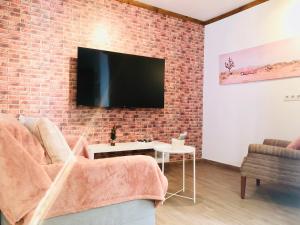un soggiorno con TV su un muro di mattoni di Apartment Alegria in Mozaga a Mozaga