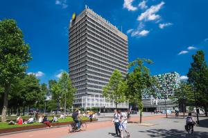 a tall building with people riding bikes in a park at Beautiful apartment in vibrant Utrecht City Center in Utrecht