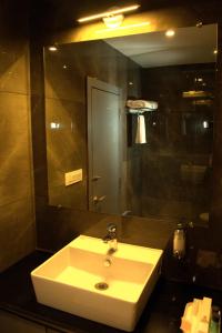 a bathroom with a white sink and a mirror at Hotel Tanisha in Kishanganj Bazar