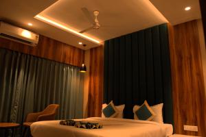 a hotel room with two beds and a ceiling at Hotel Tanisha in Kishanganj Bazar