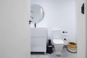a white bathroom with a toilet and a mirror at AT Presidente Nº2 apartamento privado completo in Seville