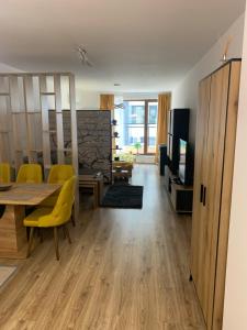 Una sala de estar con una mesa de comedor y sillas amarillas. en SOFIA CENTRAL LUXURY APARTMENT "2B" with parking, en Sofía