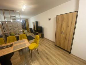 a living room with a table and yellow chairs at SOFIA CENTRAL LUXURY APARTMENT "2B" with parking in Sofia