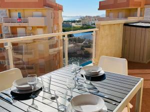 a table with glasses and plates on a balcony at Puerto Mar Fase I - Atico in La Manga del Mar Menor