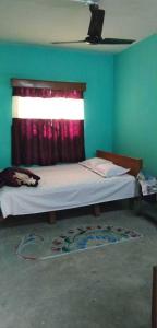 1 dormitorio con 1 cama con ventana y alfombra en Prakrity Village Resort Sundarbans, en Gosāba