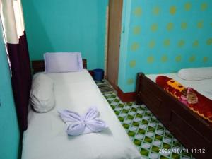 1 dormitorio con 2 camas con flores púrpuras en Prakrity Village Resort Sundarbans, en Gosāba