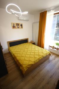 a bedroom with a bed with a yellow bedspread at SOFIA CENTRAL LUXURY APARTMENT "2B" with parking in Sofia