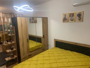 a bedroom with a yellow bed and a mirror at SOFIA CENTRAL LUXURY APARTMENT "2B" with parking in Sofia