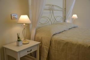 um quarto com uma cama e uma mesa com 2 candeeiros em Incantea Resort em Tortoreto Lido