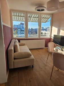 een woonkamer met een bank, 2 stoelen en ramen bij ABA2 in Zagreb