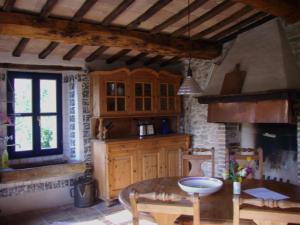 Antico-Borgo-Le-Torricelle-Grosses-Haus في Piandimeleto: مطبخ مع طاولة وكراسي في غرفة