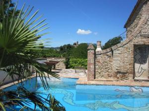 a swimming pool in a yard with a stone wall at Antico-Borgo-Le-Torricelle-Grosses-Haus in Piandimeleto