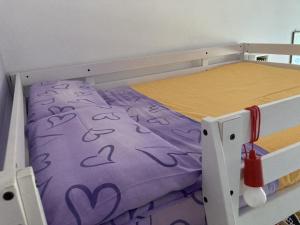 a bunk bed with a purple comforter on it at La stanza dei segreti in Aosta