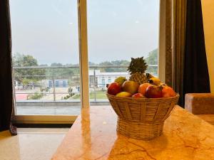 a basket of fruit on a table in front of a window at Shree Yog Maya Resort in Pushkar
