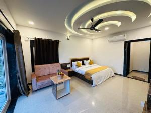 a bedroom with a bed and a table and a ceiling at Shree Yog Maya Resort in Pushkar +32 photos