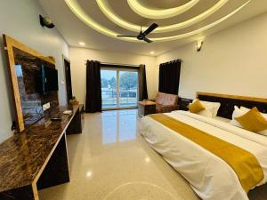 a large bedroom with a large bed and a tv at Shree Yog Maya Resort in Pushkar