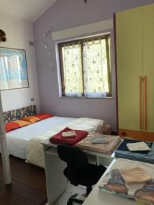 1 dormitorio con 2 camas, escritorio y ventana en La stanza dei segreti, en Aosta