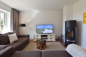 a living room with a couch and a flat screen tv at Ferienhaus Helen in Morsum
