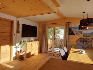 a living room with a table and a television in a cabin at Panoramaplatzl in Goldegg