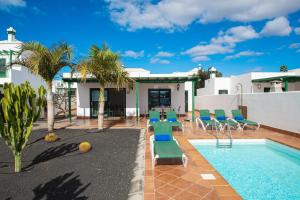 a villa with a swimming pool and palm trees at Blancazul Brisa Marina in Yaiza