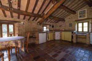 una grande cucina con soffitti in legno in un edificio di Antico-Borgo-Le-Torricelle-Kleines-Haus a Piandimeleto