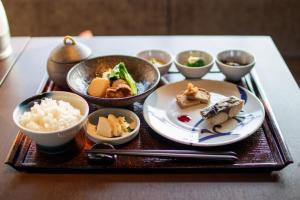 a tray with plates of food and bowls of rice at NIPPONIA HOTEL Ozu Castle Town in Ōzu