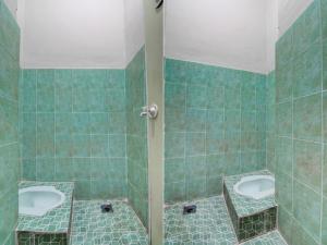 een badkamer met twee wastafels en twee urinoirs bij SPOT ON 92635 Homestay Baiturrahmah Syariah in Pekanbaru
