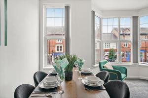 a dining room with a table and chairs and windows at Large Stylish Duplex in Central Leicester - Sleeps 8 in Leicester