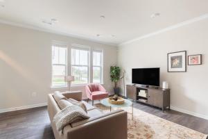 un soggiorno con un divano e una TV di Ashburn 3br w wd nr airport national park WDC-764 ad Ashburn