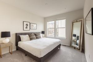 una camera da letto con un letto grande e uno specchio di Ashburn 3br w wd nr airport national park WDC-764 ad Ashburn Altre 17 foto