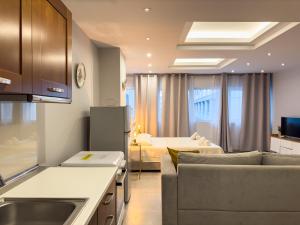 a kitchen and living room with a couch and a bed at Glamorous & Spacious Renovated Apartment, Syntagma, DT Athens in Athens