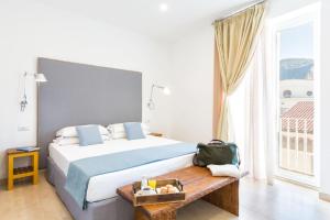 a bedroom with a large bed and a large window at Boutique Suites 186 in Sorrento