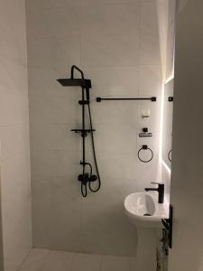 a white bathroom with a shower and a sink at استديو انيق وجميل بدخول ذاتي in Riyadh