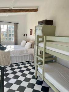 a bedroom with two bunk beds and a checkered floor at Holiday Home Villa St Arnoux in Seillans