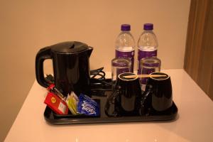 a black tray with two bottles of water and glasses at Hotel Tanisha in Kishanganj Bazar