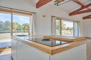une cuisine avec un îlot et un comptoir dans l'établissement Domaine de Badine, 15 min Bordeaux & Saint-Emilion, à Saint-Sulpice-et-Cameyrac
