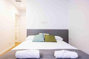 a bedroom with a large white bed with two pillows at Apartamentos turísticos Plaza Sevillano , by CartagenaSpain in Cartagena