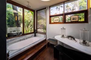 a bathroom with a large tub and windows at Villa Manis Beachfront Candidasa in Candidasa +108 photos