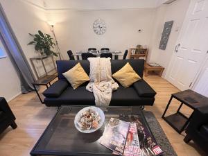 a living room with a black couch and a table at Glazebrook in London