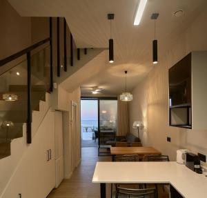 a living room with stairs leading to the ocean at Ancón Suites in Carboneras