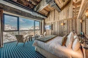 a bedroom with a bed and a large window at Le Refuge de Solaise - 2551 m Altitude in Val-d'Isère