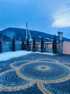 een grote stenen cirkel op een binnenplaats met een klokkentoren bij садиба Дерев*яна Хата in Verkhovyna