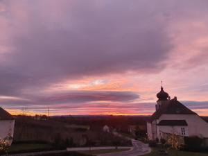 a church with a sunset in the background at Freigut Thallern in Gumpoldskirchen